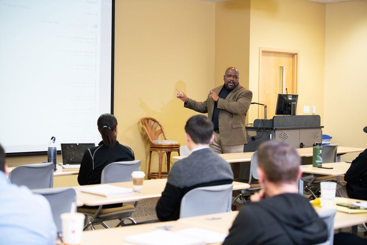 A professor speaking in front of a class.